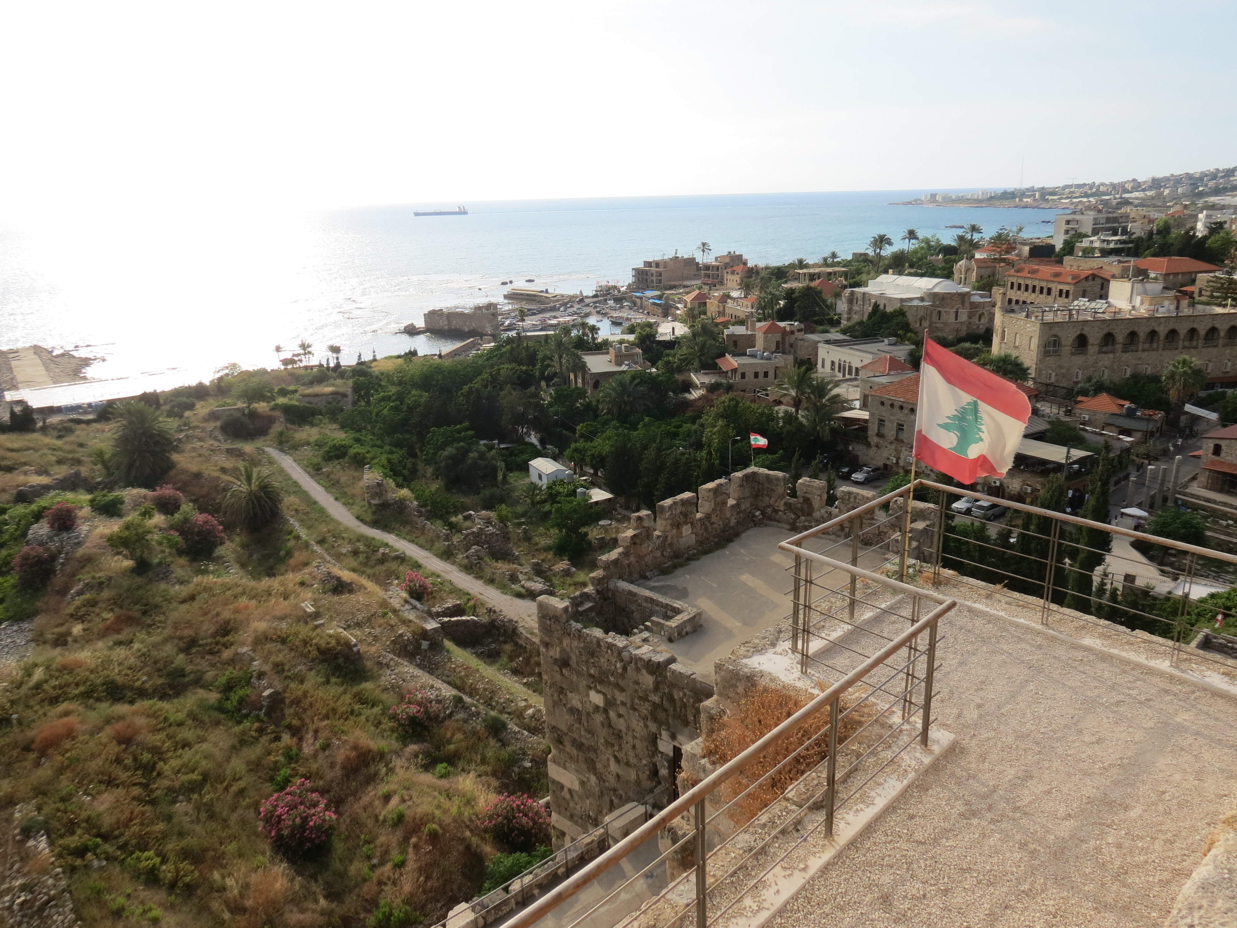 A Lebanese flag flying above Byblos Castle, overlooking the old town and Mediterranean Sea